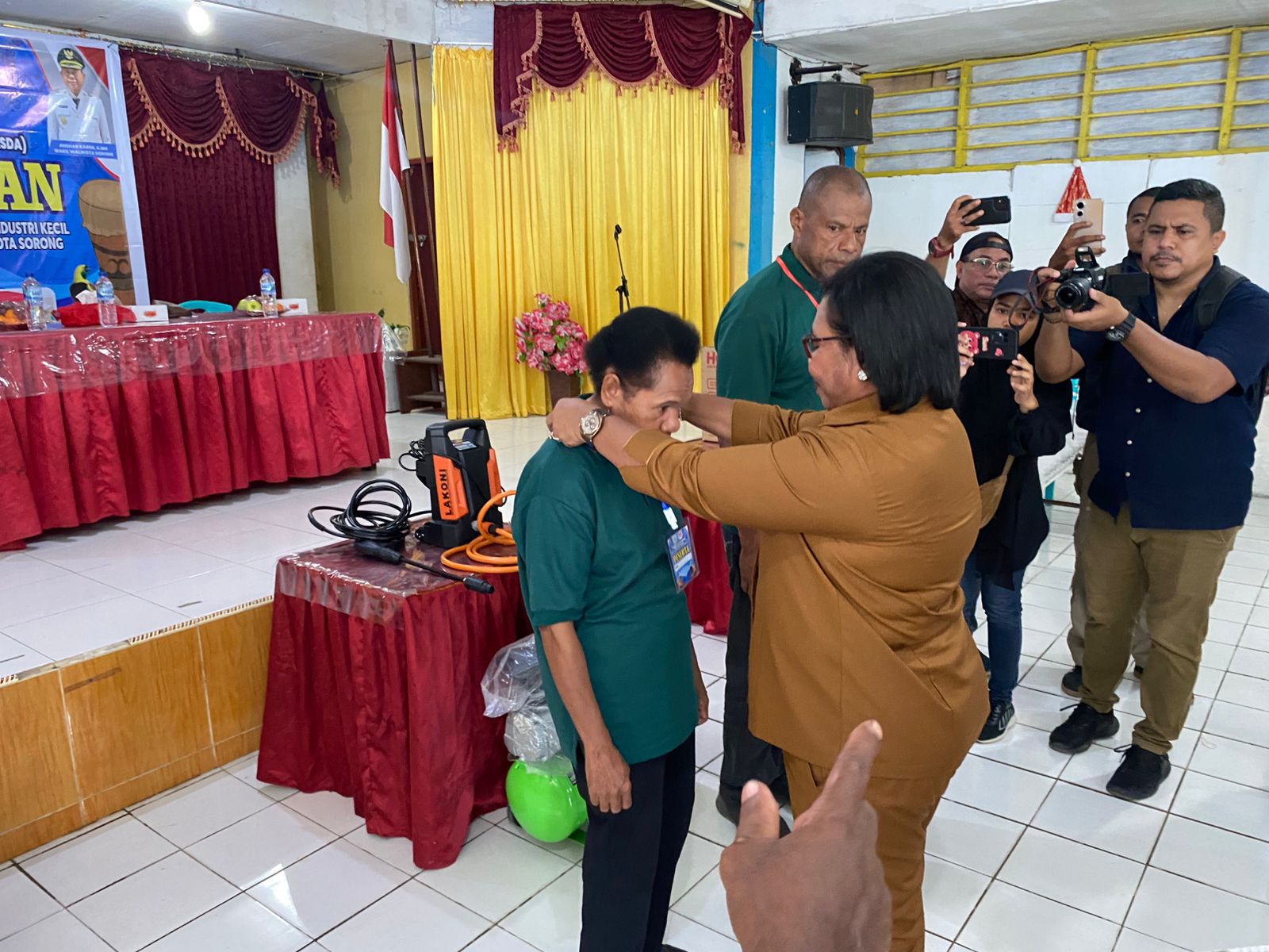 Ketua Dekranasda Kota Sorong, Jemima Elisabeth Lobat menyematkan kartu tanda peserta kepada salah satu perwakilan