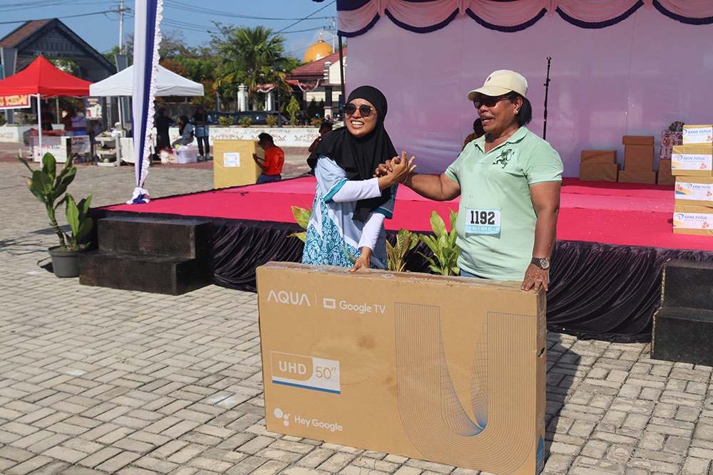 Plt. Kepala Dinas Kesehatan Kota Sorong, Jemima Elisabeth Lobnat, S.K.M., MAP, saat menyerahkan hadiar door prize